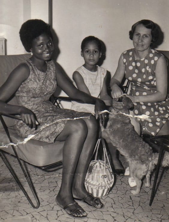 Two women, a child and a dog in a 1960s interior
